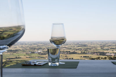 Close-up of wineglass on table against clear sky