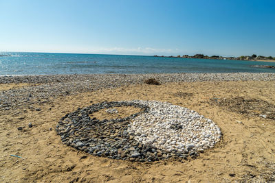 Sea shore on sand at beach against sky