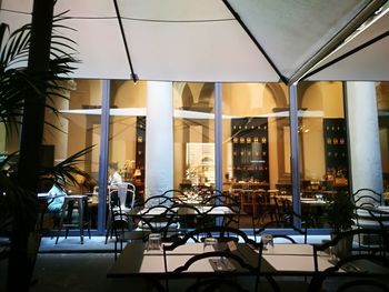 Empty chairs and tables in illuminated building