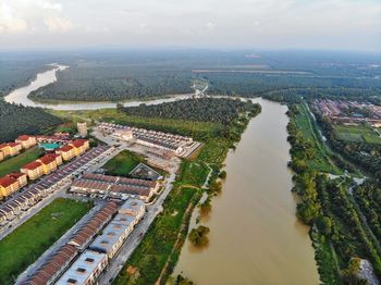 Aerial view of river by town against sky