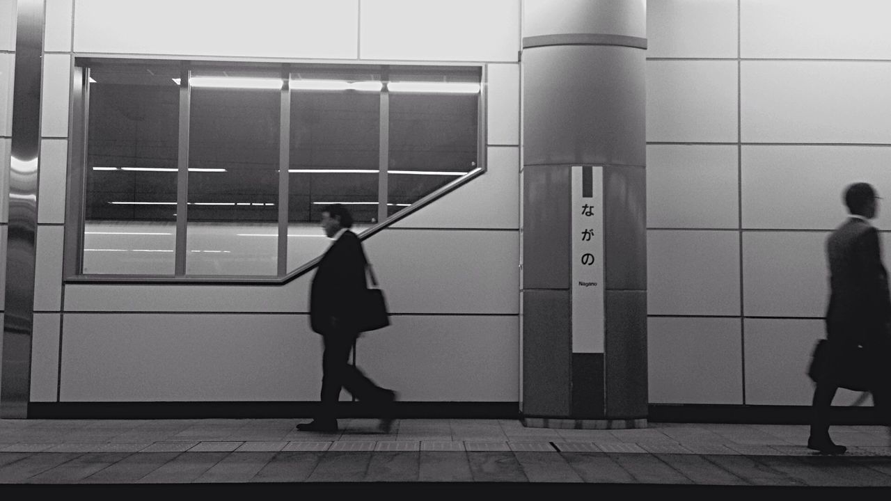 lifestyles, architecture, built structure, full length, men, walking, building exterior, standing, person, leisure activity, rear view, casual clothing, building, city, city life, shadow, day, street