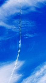 Low angle view of vapor trail against blue sky