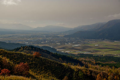 Scenic view of landscape and volcanic mountains against sky