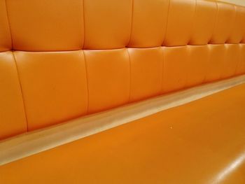 Full frame shot of sofa in orange wall