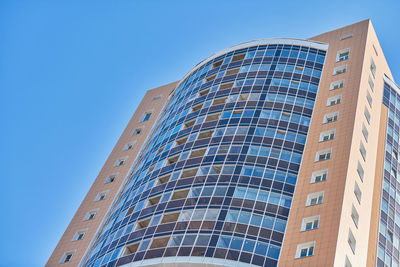 Low angle view of modern building against clear blue sky