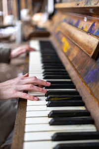 Cropped hand of woman playing piano