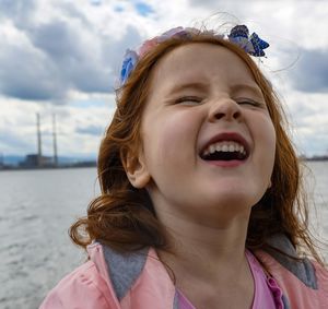 Close-up of smiling girl by lake