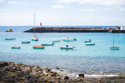 Sailboats moored on sea against sky in lanzarote 