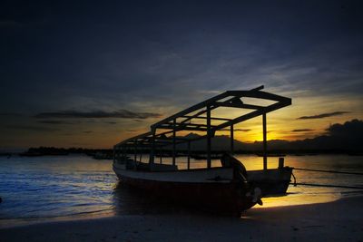 Boats in sea at sunset