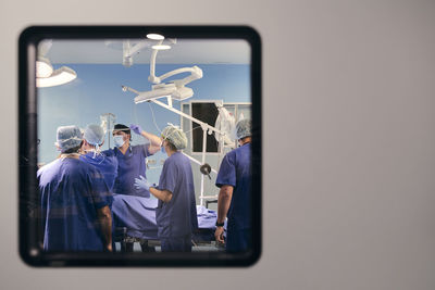 Doctors team wearing face mask working while standing in operation room at hospital