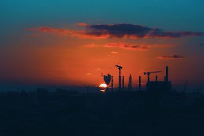 Silhouette of city against sky during sunset