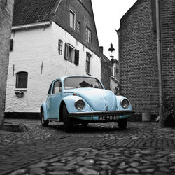 Vintage car on street amidst buildings in city