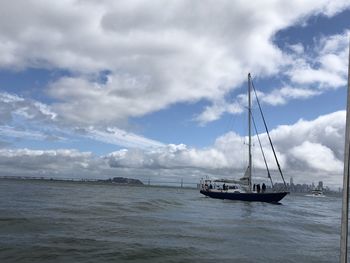 Sailboat sailing on sea against sky