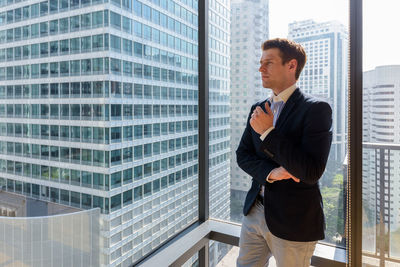 Full length of woman looking at modern building in city