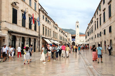 People on street in city against sky