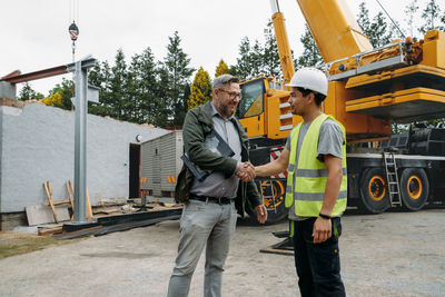 Foreman and customer or client agree about future building work on construction site. man looking in