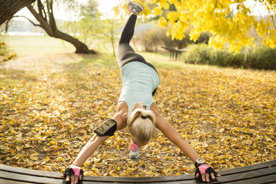 Mid adult woman exercising in park during autumn