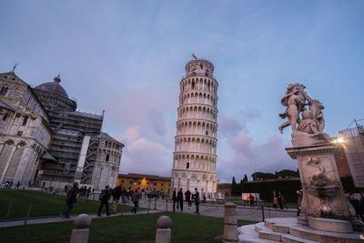 Statue in city against sky