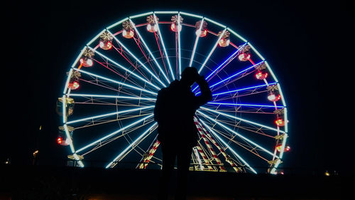 Low angle view of illuminated ferris wheel at night