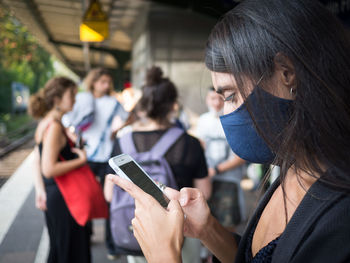 Portrait of woman holding mobile phone outdoors
