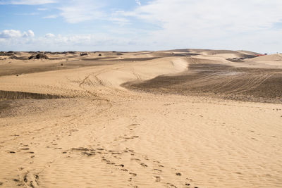 Scenic view of sand dunes against sky