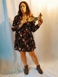 Portrait of woman standing against wall