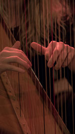 Midsection of woman playing harp