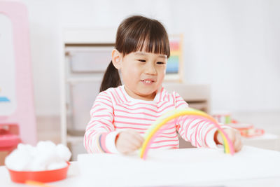 Cute smiling girl playing with toy