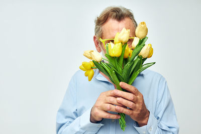 Portrait of senior man holding flower bouquet