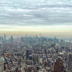 Aerial view of city against cloudy sky