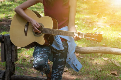 Midsection of man playing guitar