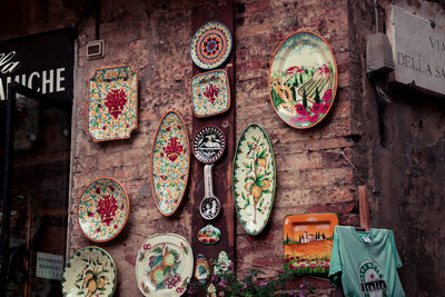 Decorated souvenir plates on a street wall in italy