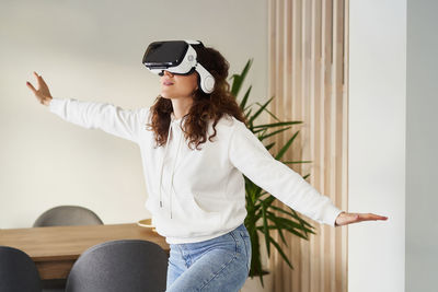 Young woman looking away while sitting on floor