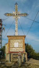 Traditional windmill on street amidst buildings against sky