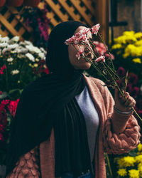 Midsection of person holding flowering plant