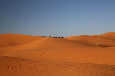 Scenic view of desert against clear blue sky