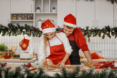 Christmas gingerbread. sweet happy joyful couple decorating freshly baked cookies. christmas time