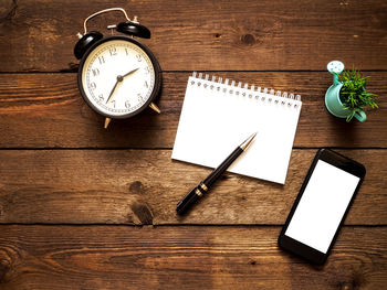 High angle view of clock and book on table