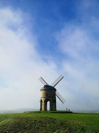 Traditional windmill on field against sky