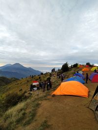 Group of people on mountain road against sky