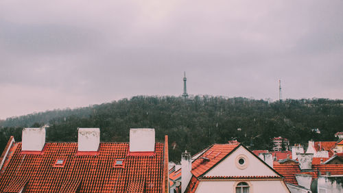 Houses by building against sky