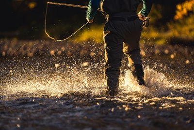 Low section of man playing in water