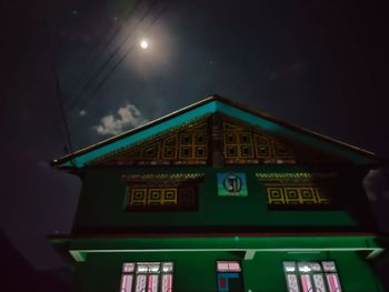 Low angle view of illuminated building against sky at night