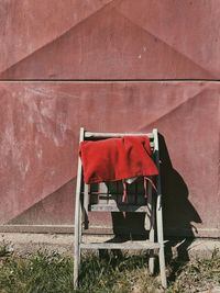 Empty chair against red wall