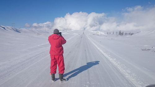 Rear view of person standing on snow covered landscape