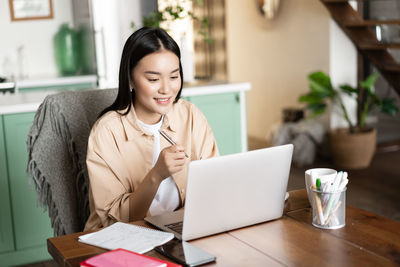 Young woman using laptop at table