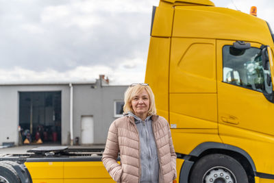 Smiling woman standing in front of truck