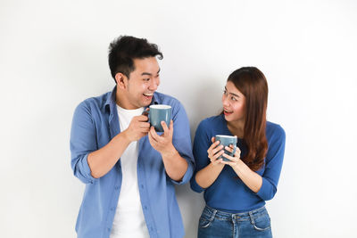 Young man and woman standing against white background