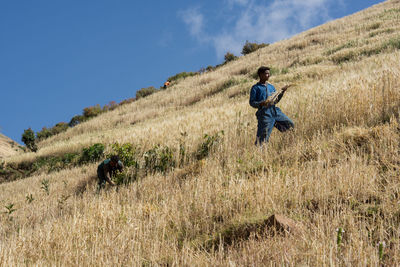 Rear view of man on field against sky