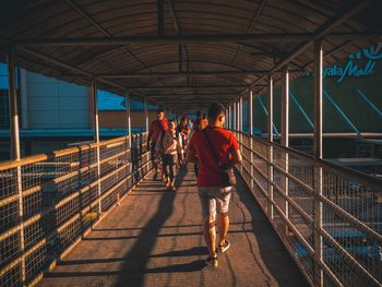 Rear view of people walking on footbridge